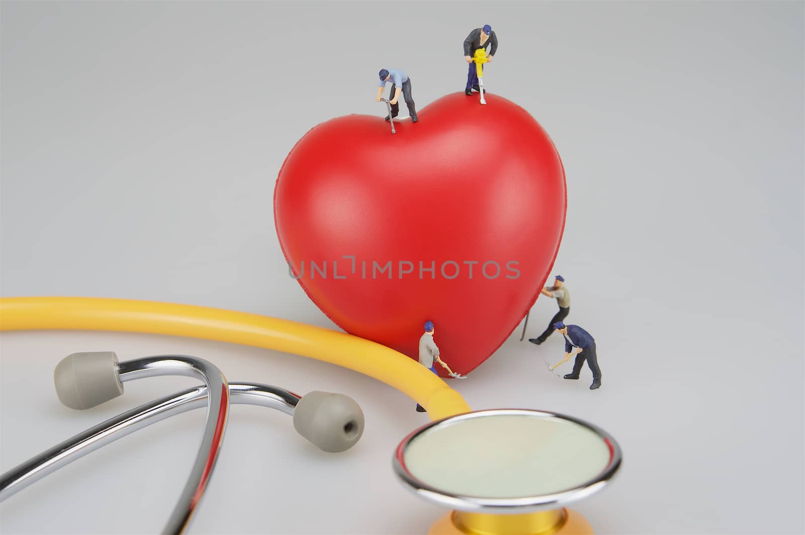 Miniature people with red heart and stethoscope by ninun