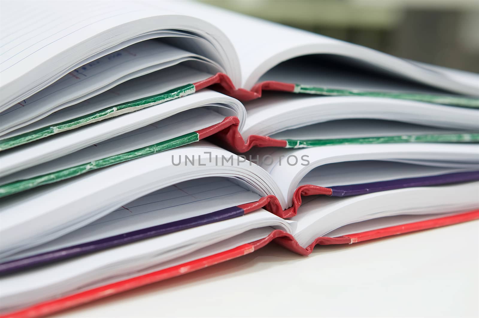 Open of many report book on desk with office background.