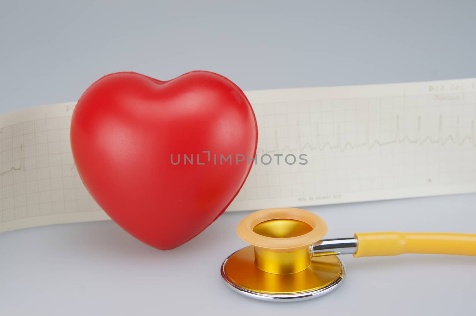 Medical stethoscope with red heart and electrocardiogram  on white background.
