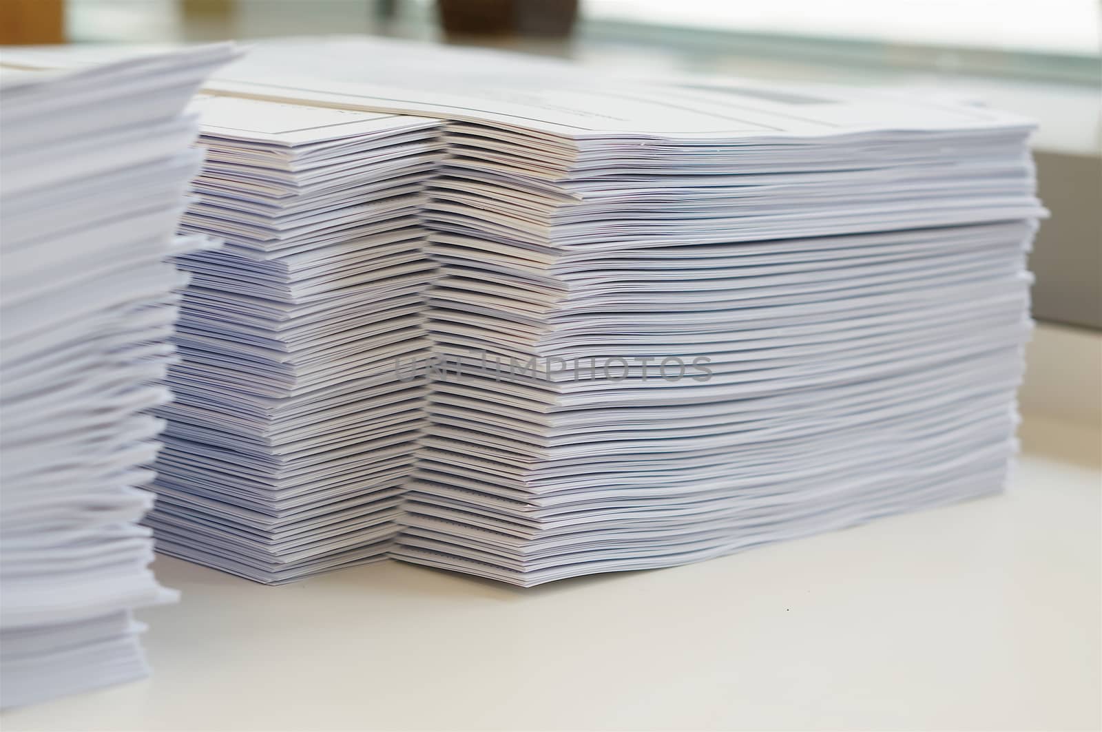 Stack of white papers sheet was organized  on office background.                                