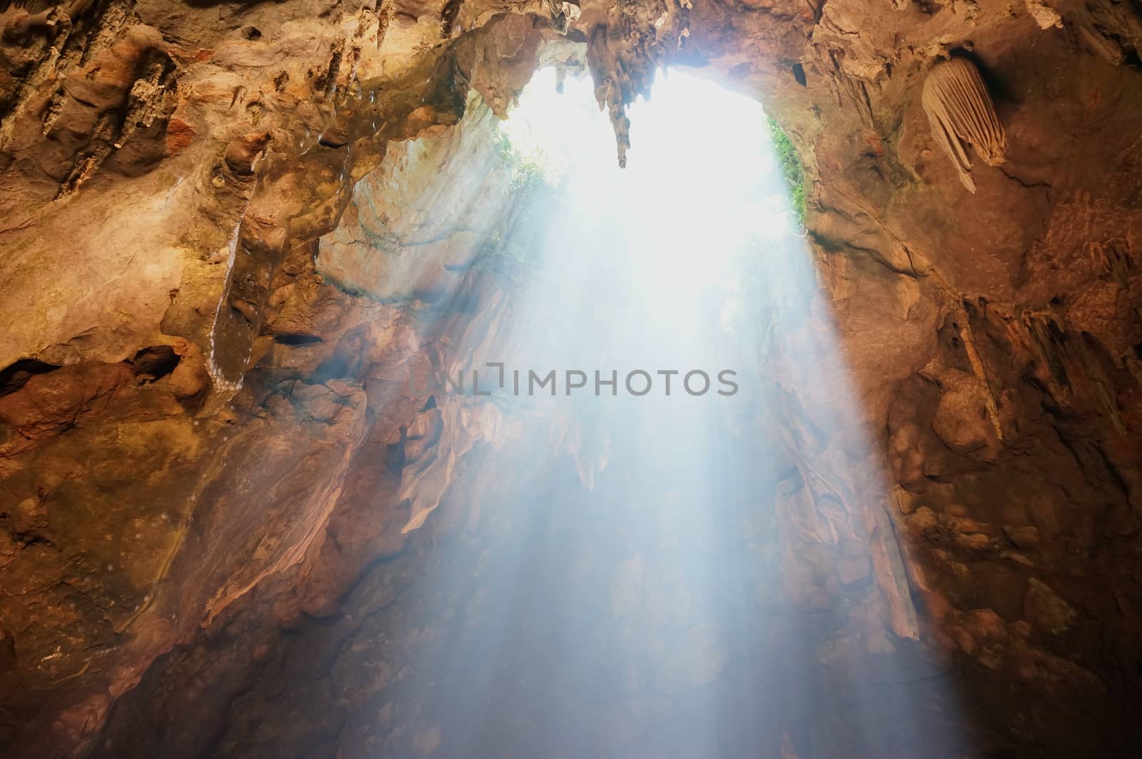 Sun rays in cave and beautiful stalactites formation in Thailand.           