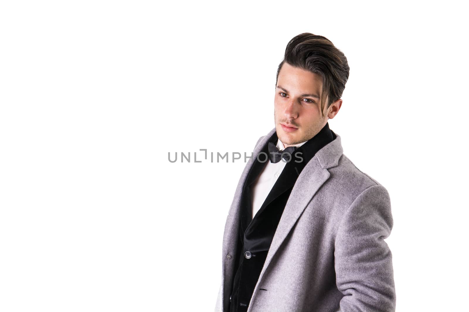 Young businessman confidently posing and looking at camera, wearing suit isolated on white background