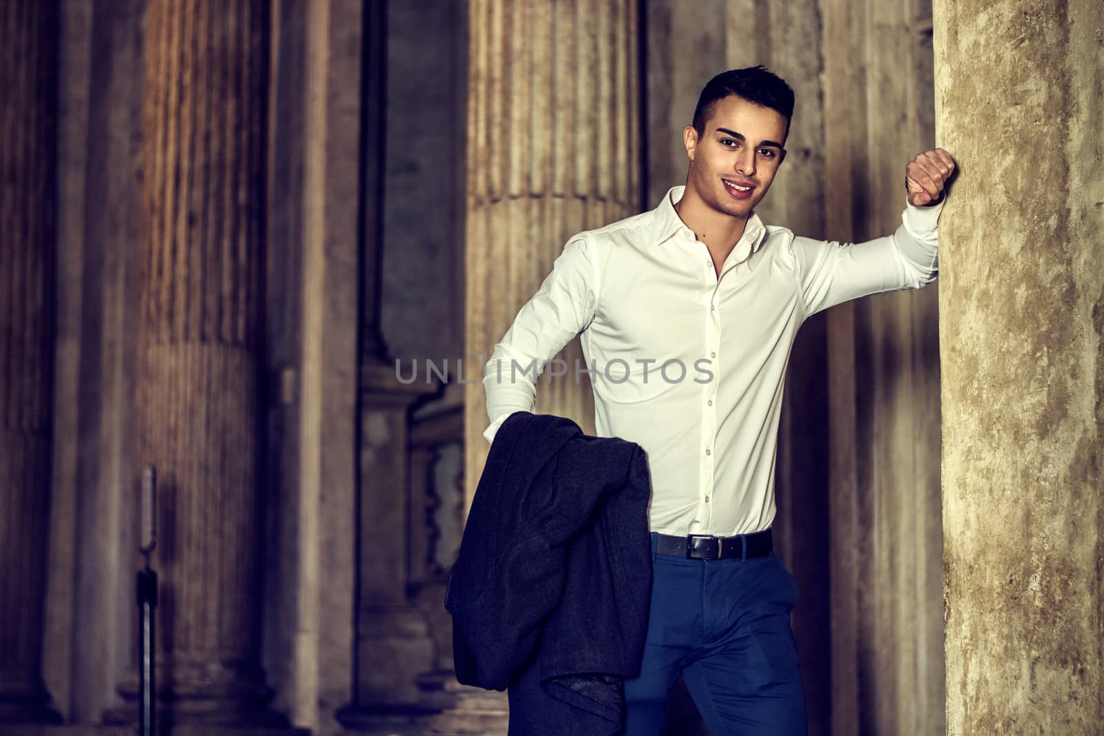Elegant attractive young man outdoor wearing business suit, in European city