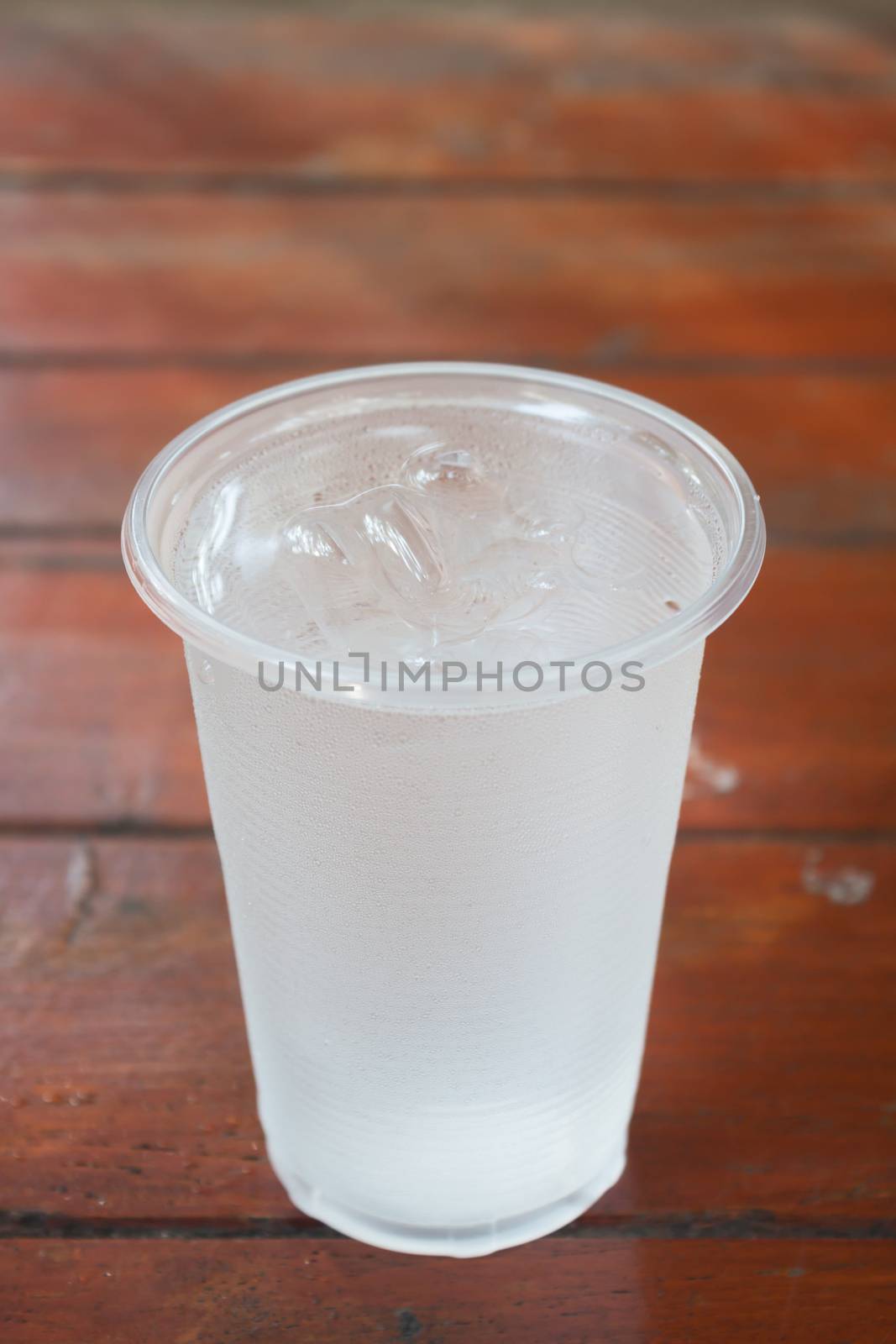 Glass of water on wooden table by punsayaporn