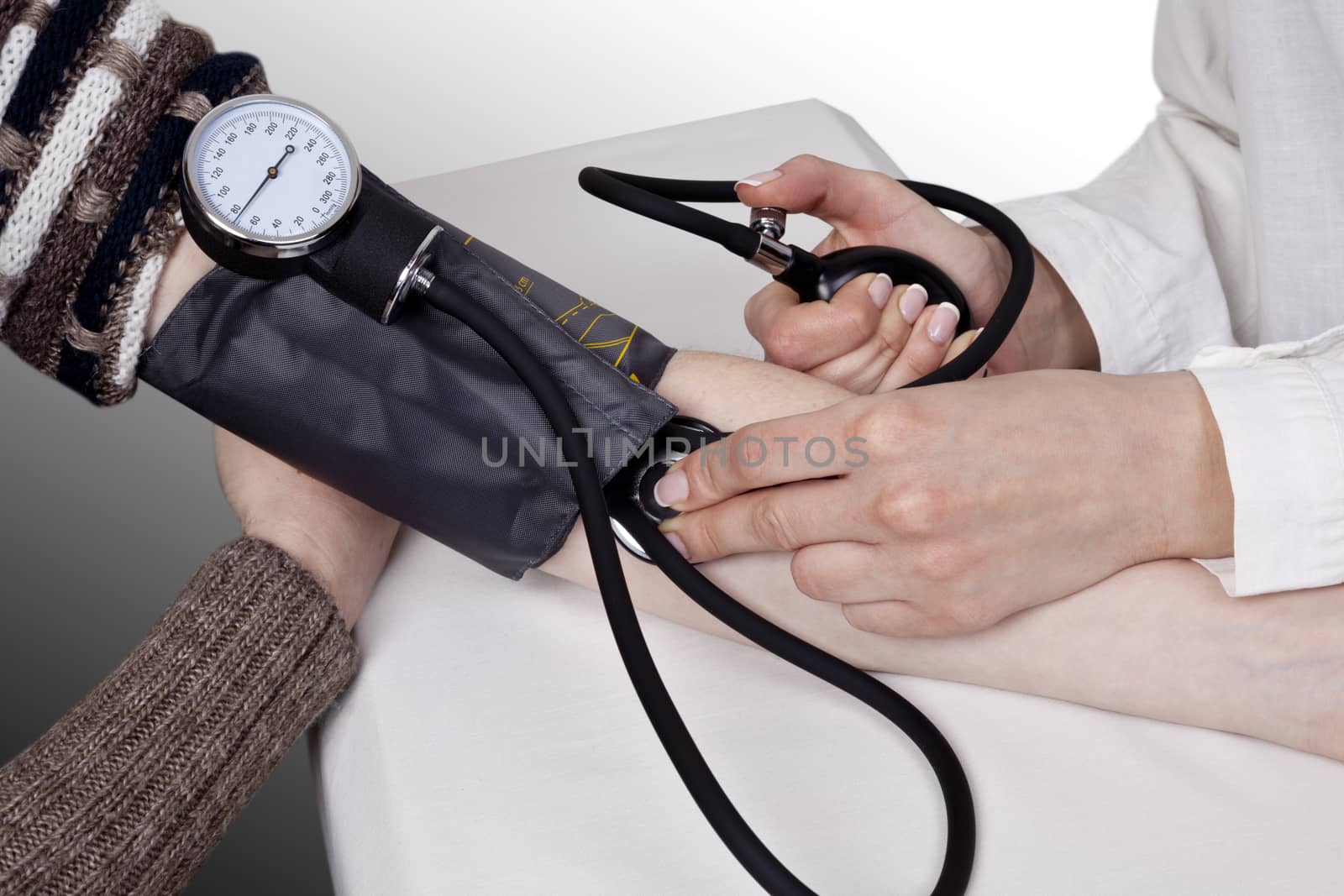 The doctor measures blood pressure in the patient