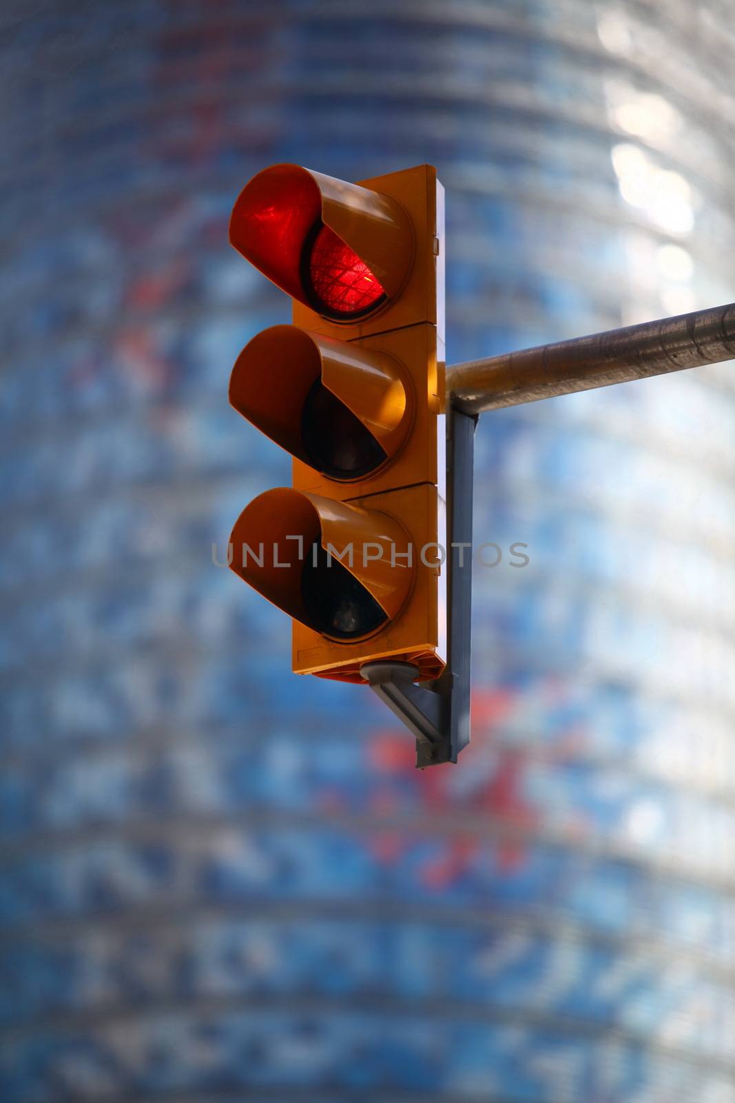 Red traffic light against the blue building