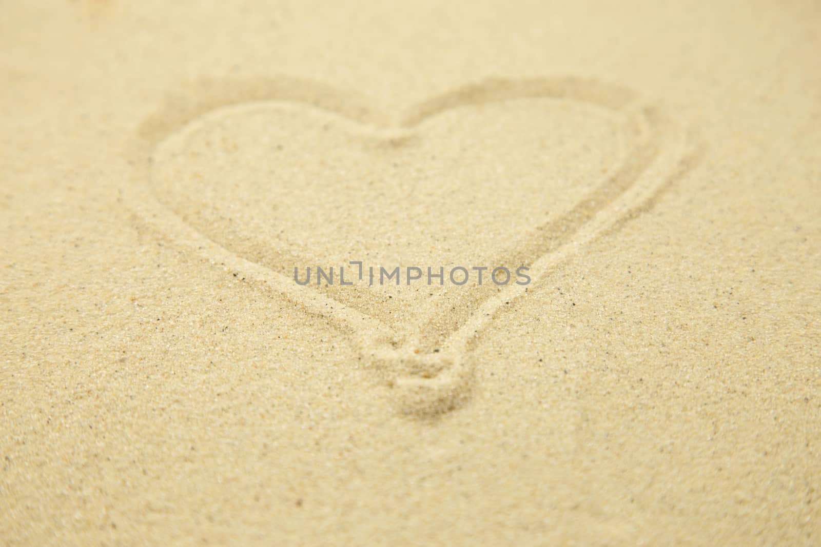 Heart drawn in the sand. Beach background. Top view