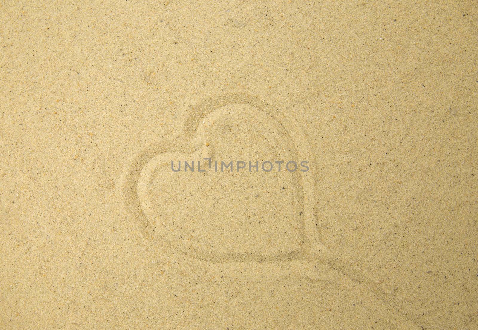 Heart drawn in the sand. Beach background. Top view