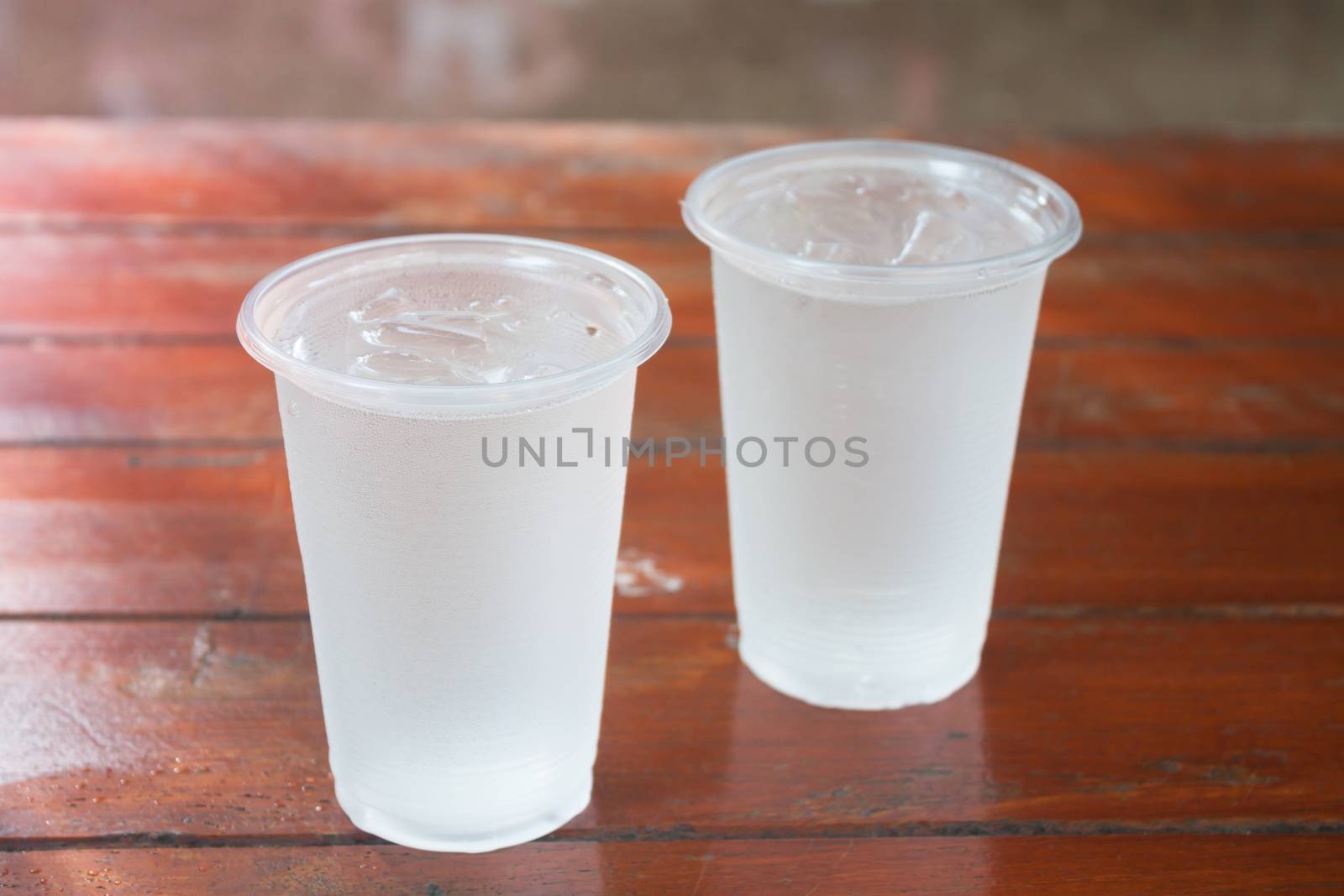 Glass of water on wooden table by punsayaporn