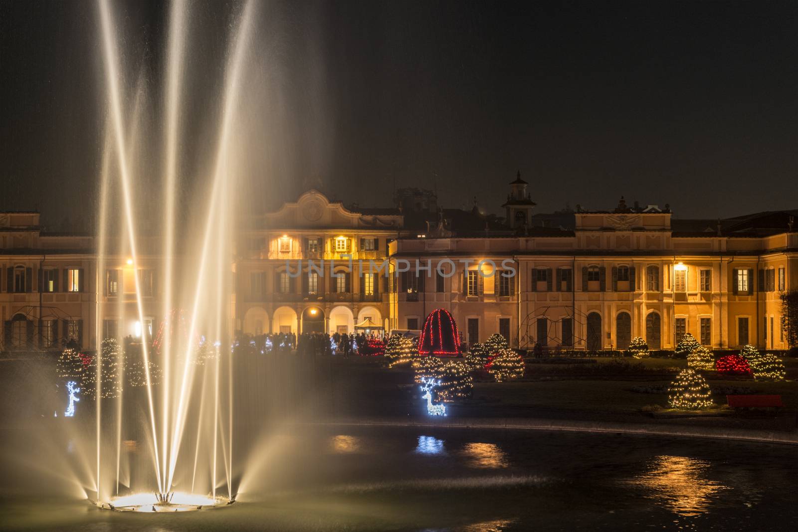 Fountain in the foreground and Christmas lights in the public gardens of Varese