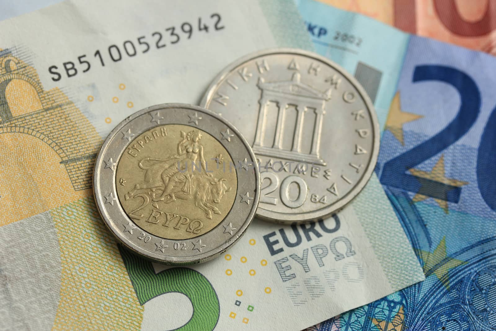 Greek Drachma and euro coin on bank note