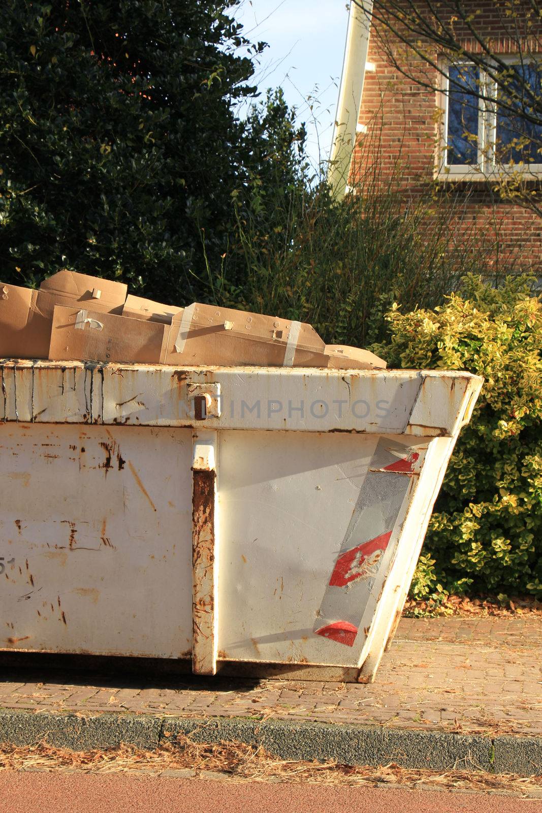 Loaded garbage dumpster by studioportosabbia