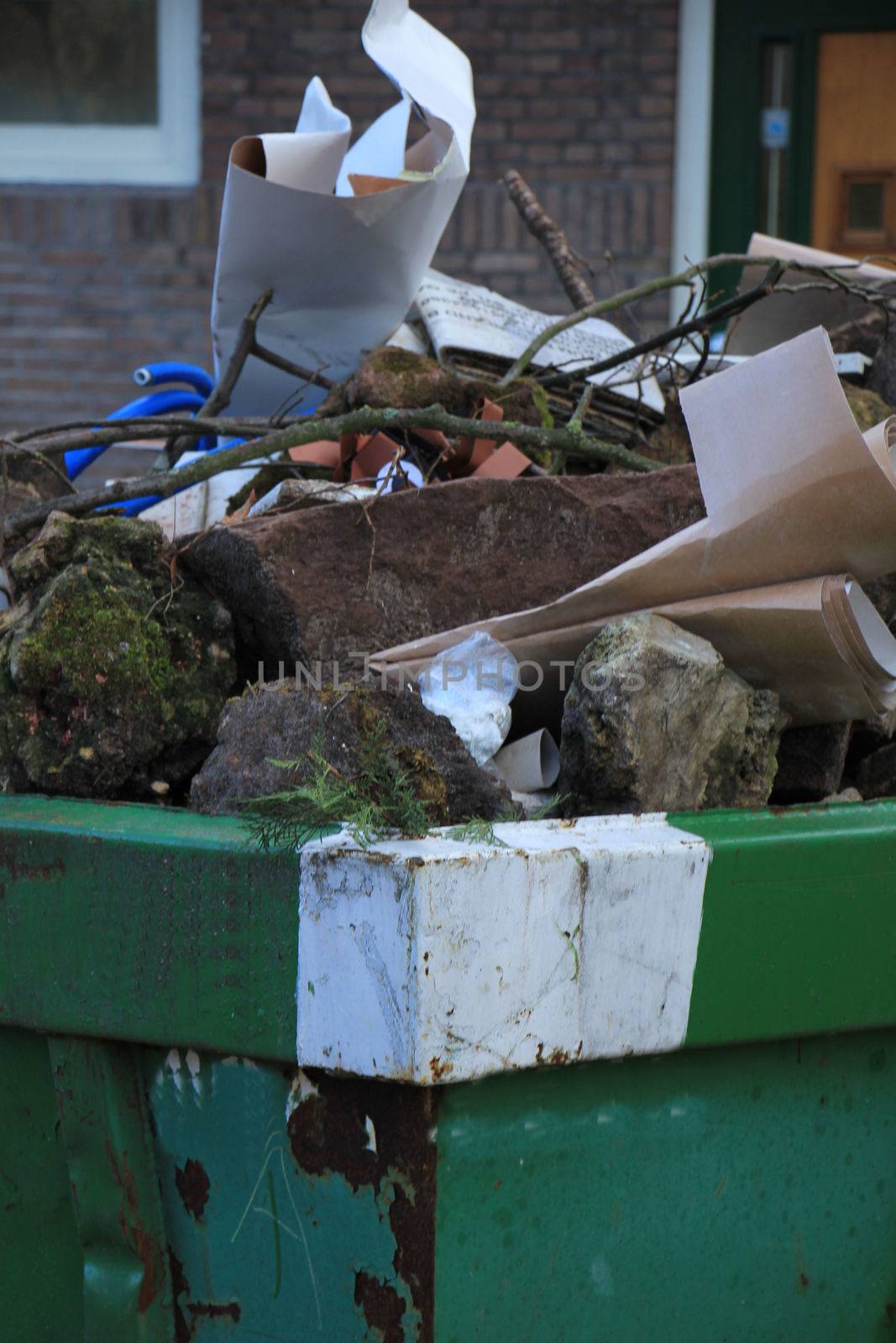 Loaded garbage dumpster by studioportosabbia