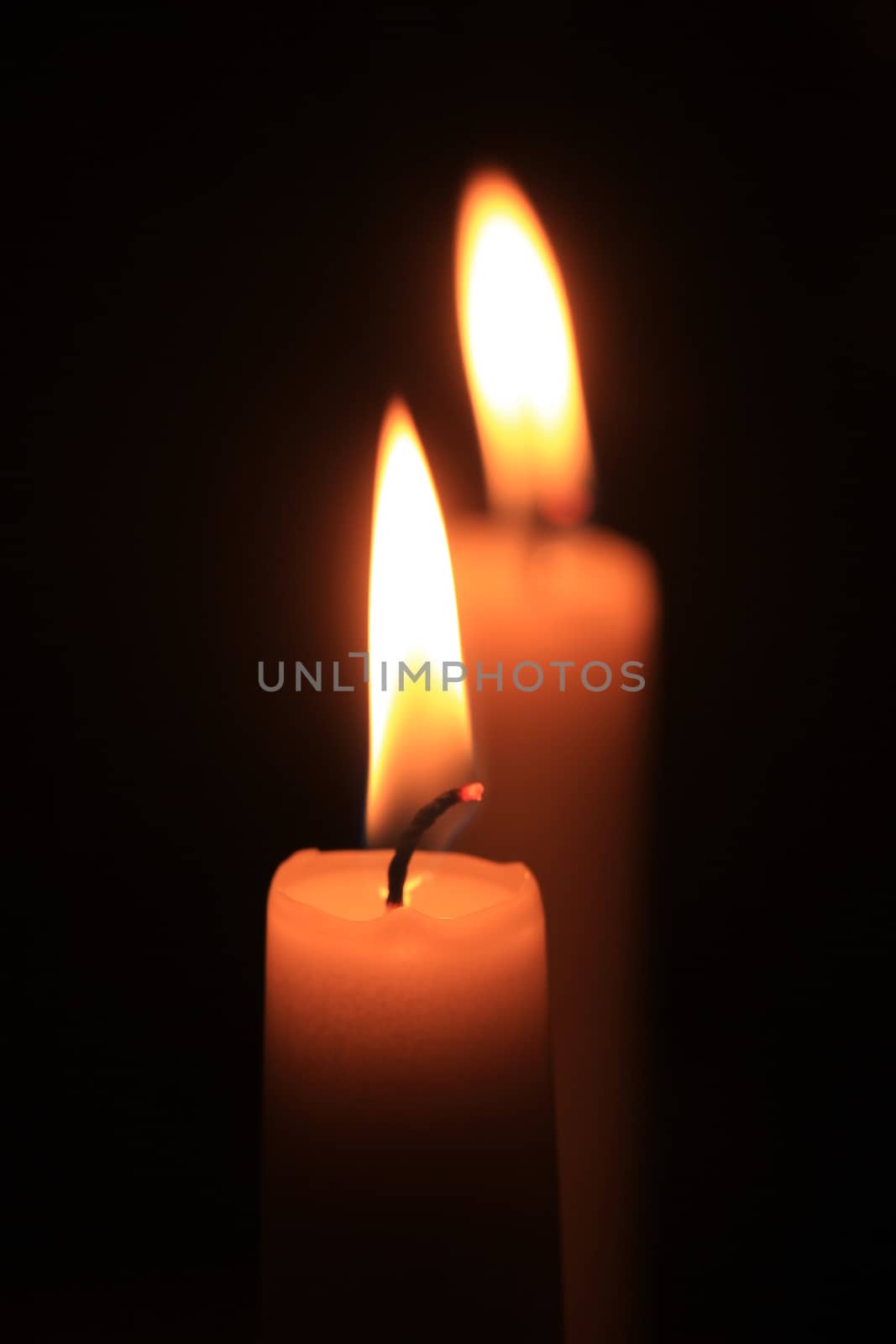 burning candle in the dark by studioportosabbia