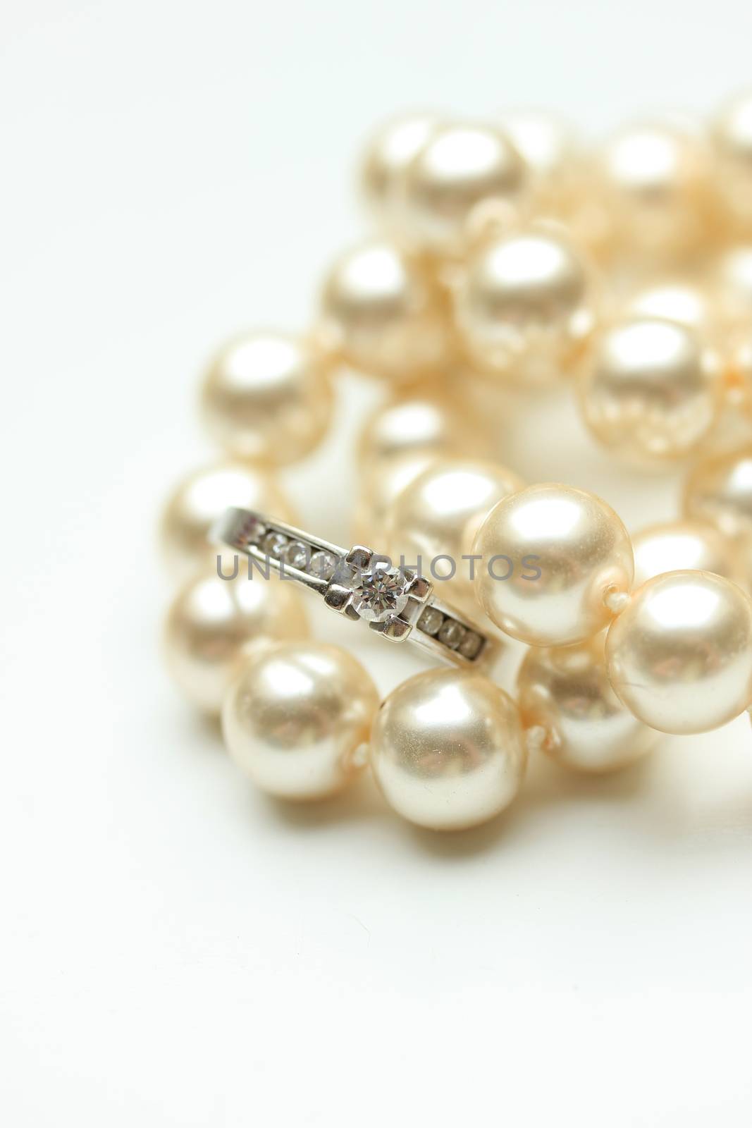 Diamond engagement ring in a channel setting and a pearl necklace