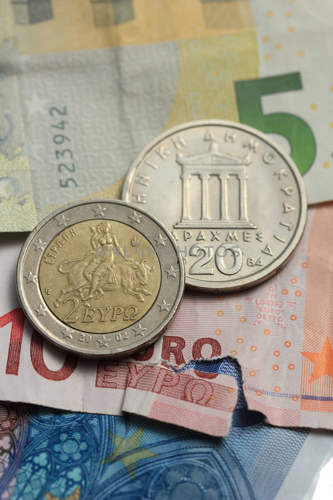 Greek coins on euro notes by studioportosabbia