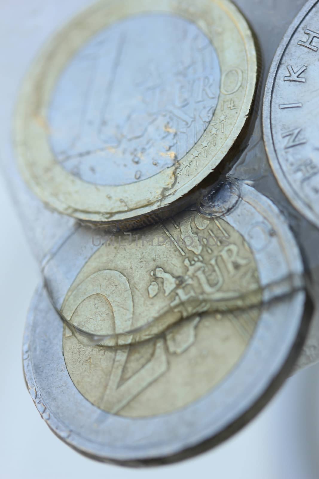 Frozen Assets: Greek euro and Drachme coins in ice