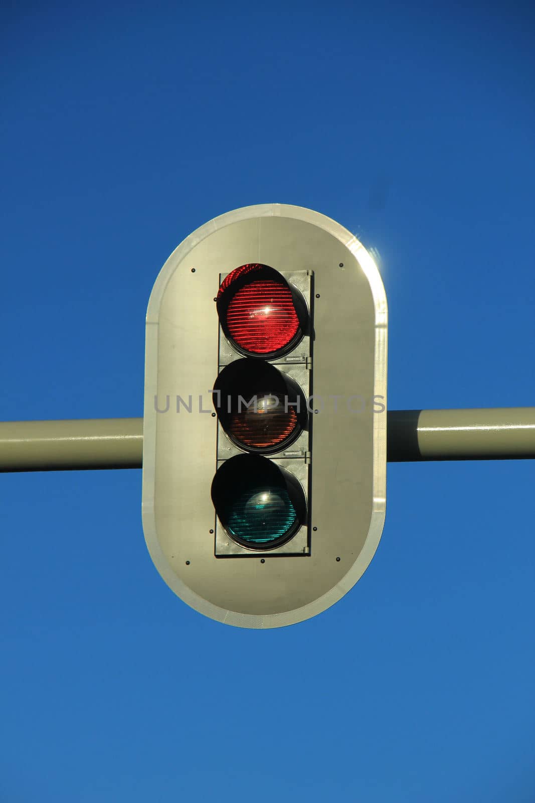 Traffic lights in a clear blue sky by studioportosabbia