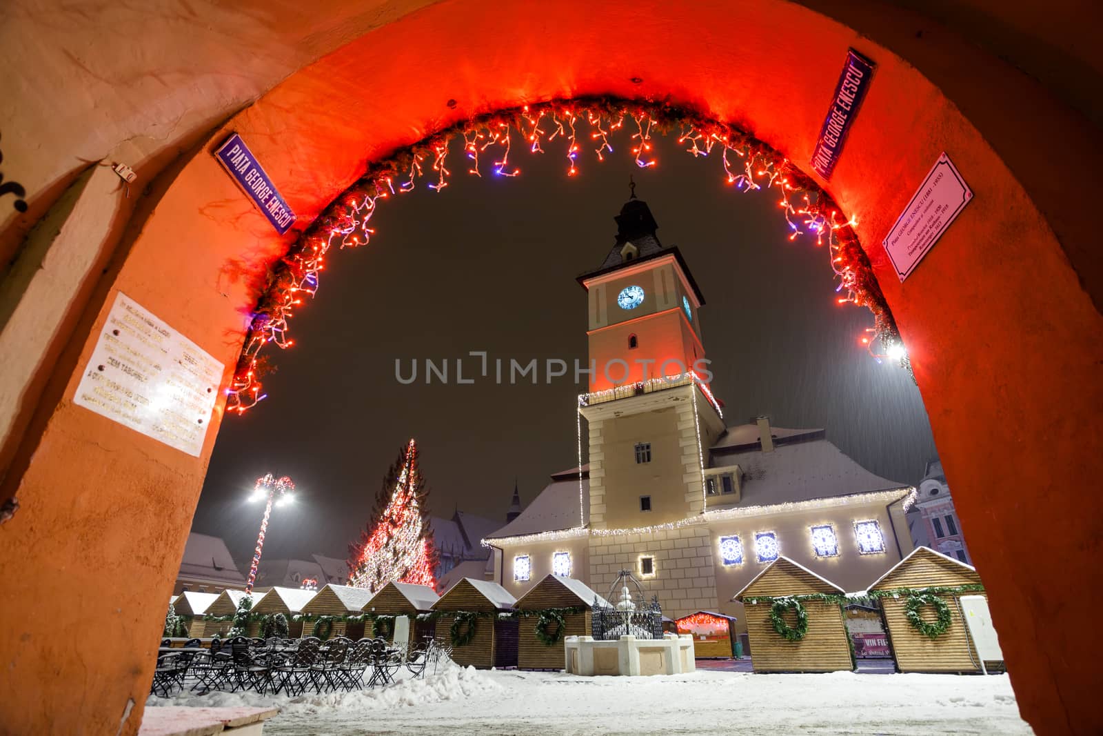 Brasov Council House night view decorated for Christmas and traditional winter market in the old town center, Romania