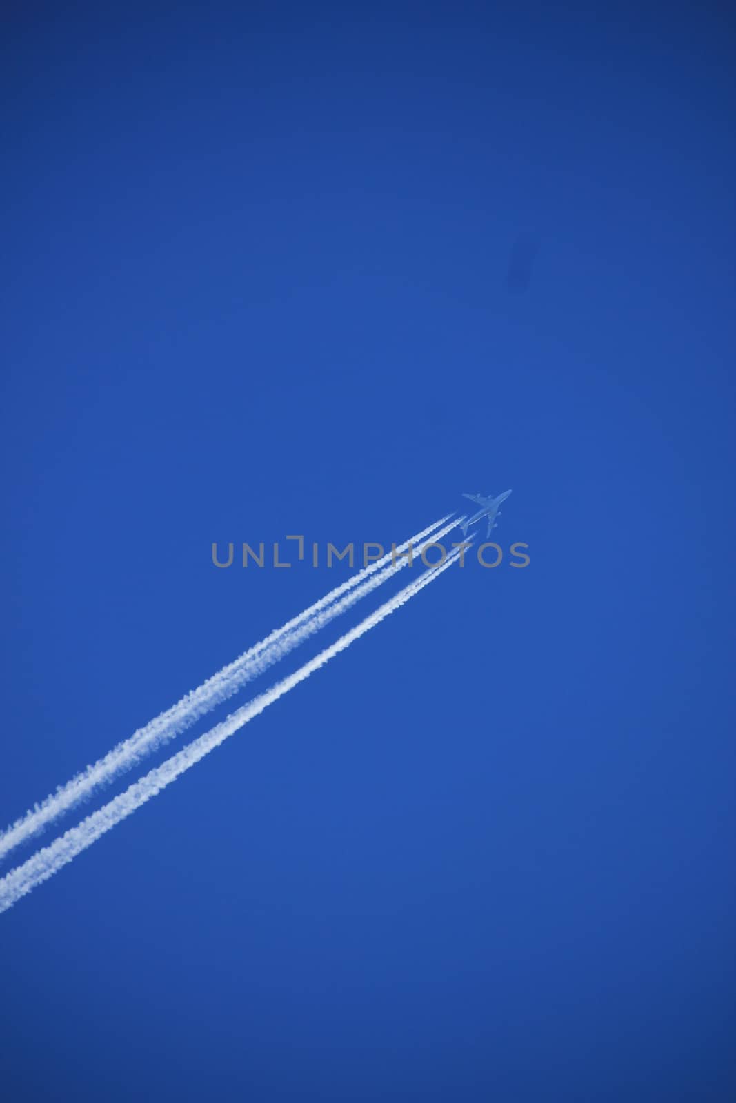 Contrails of a big airplane in a clear blue sky