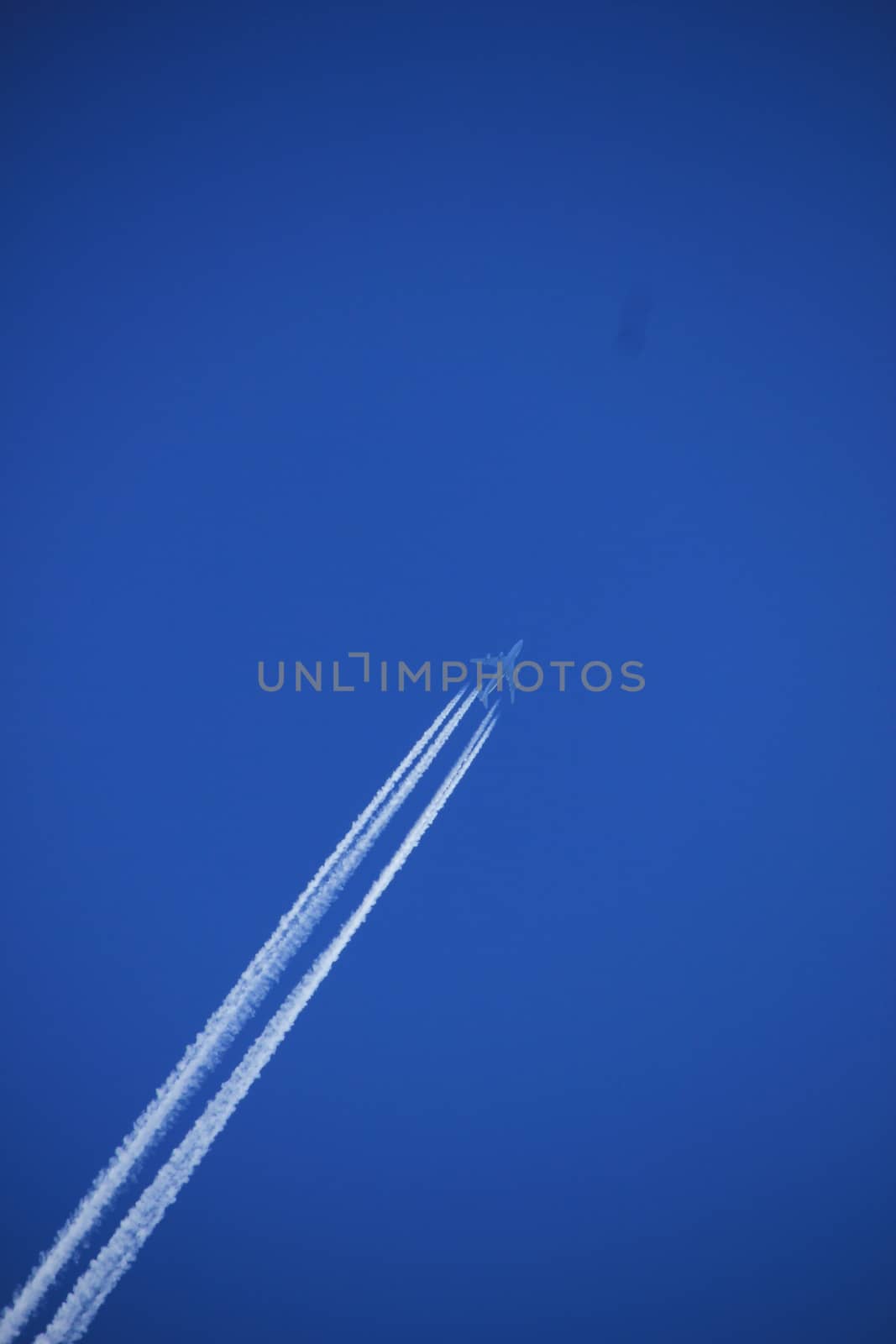 Contrails of a big airplane in a clear blue sky