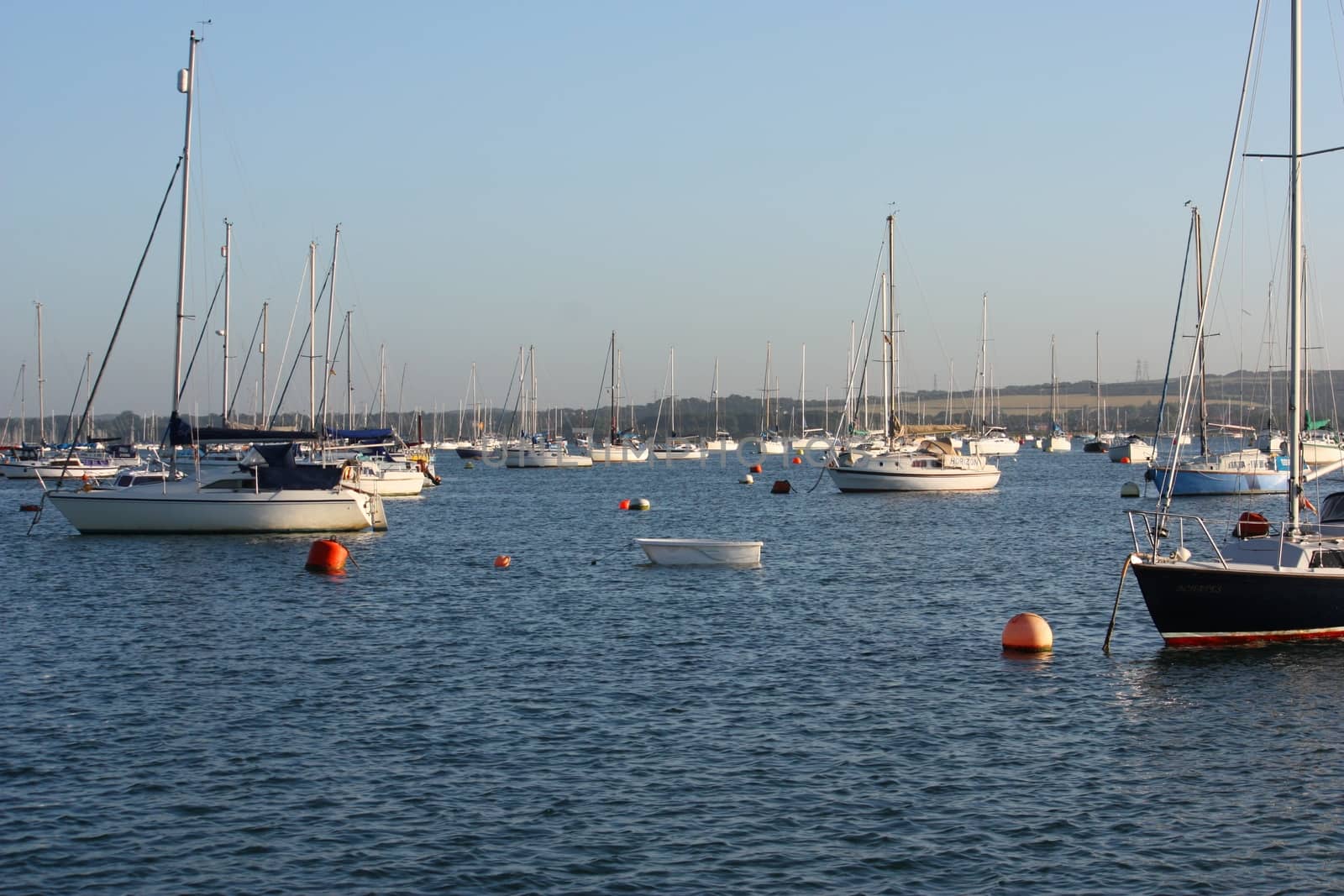 boats at anchor on a blue clam sea by chrisga