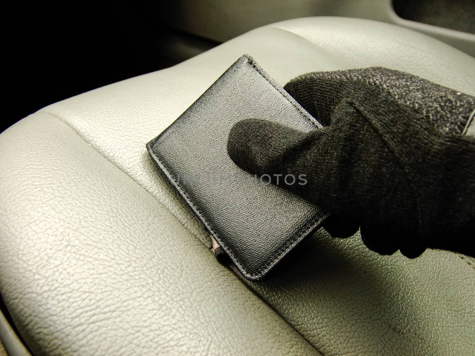 Mens Hand holding black Wallet on the Background of Front Leather Seat of A luxury Car