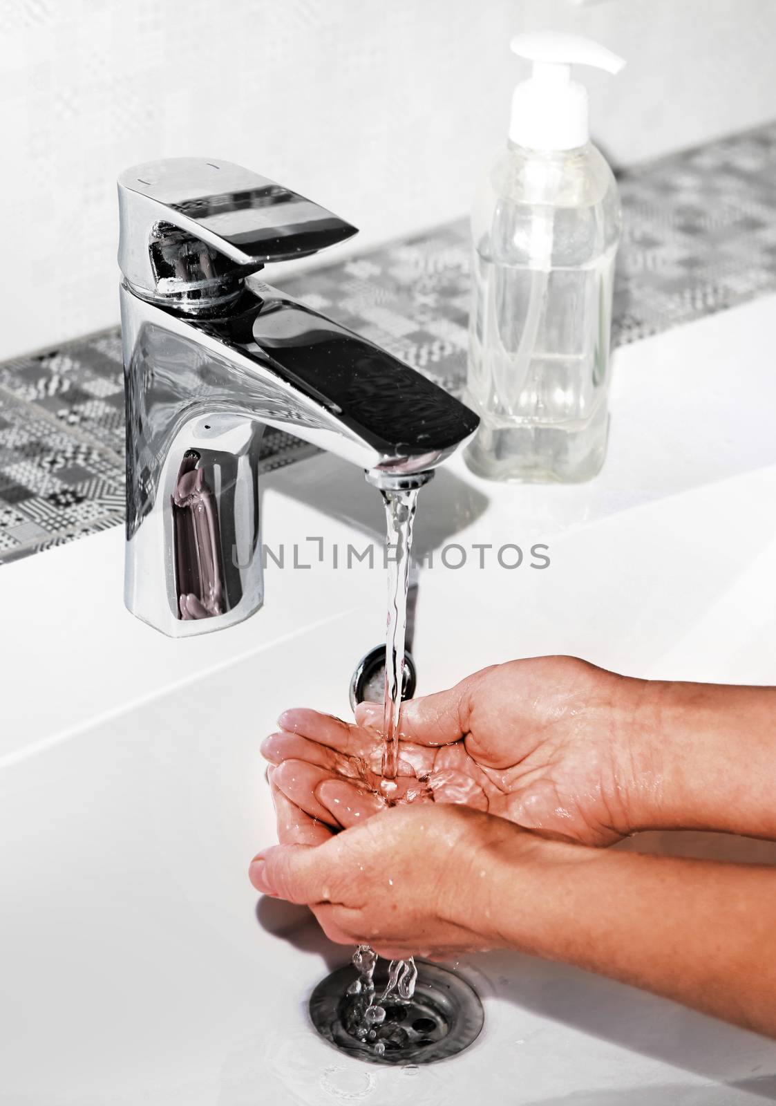 washing hands in modern sink by ssuaphoto
