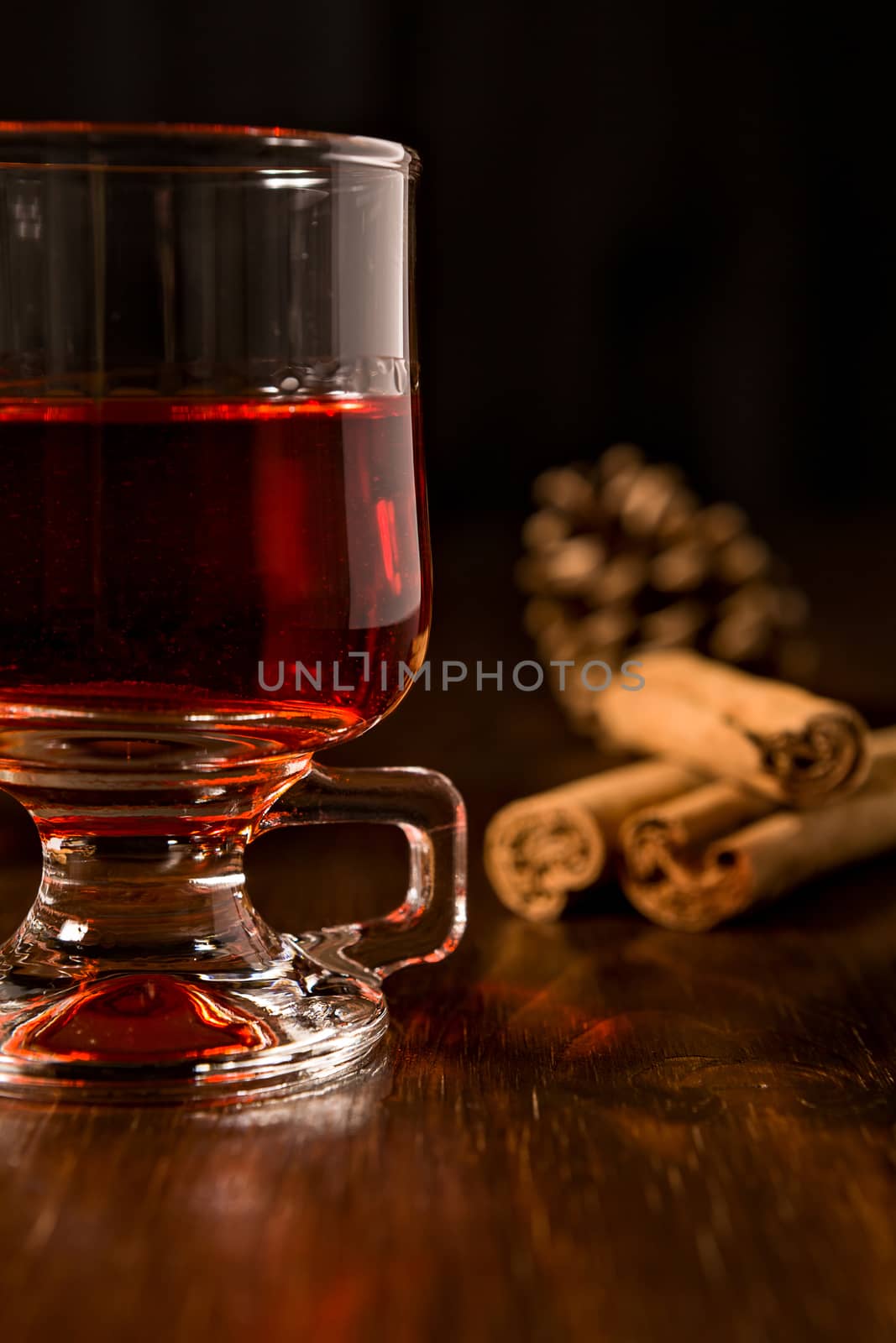 Closeup of alcoholic punch drink and cinnamon sticks on background