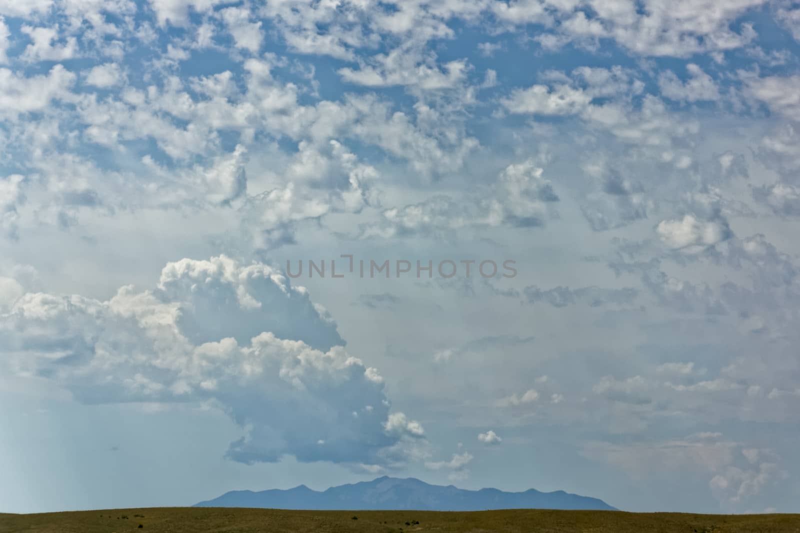 A distant mountain with beautiful clouds and sunlight overhead