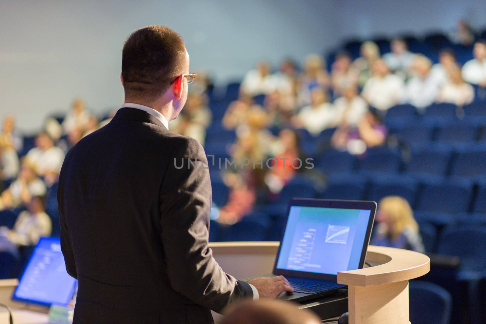 Speaker giving a talk on corporate Business Conference. Audience at the conference hall. Business and Entrepreneurship event.