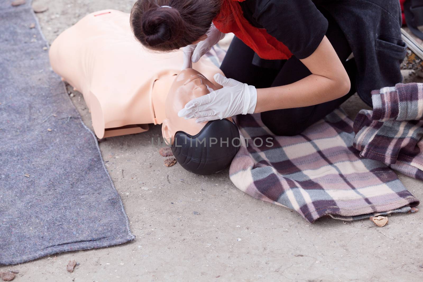 Taking a pulse. Female paramedic showing cardiopulmonary resuscitation - CPR on training dummy. by wellphoto