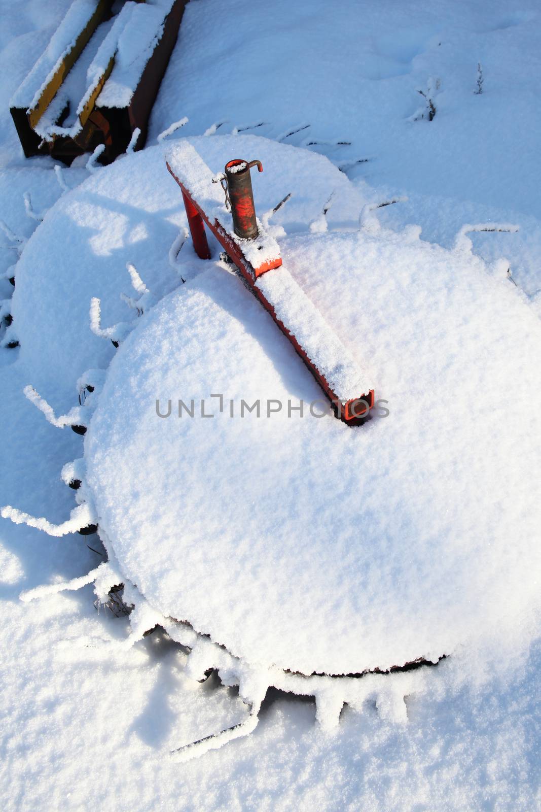 Snow covered farm equipment on a sunny day