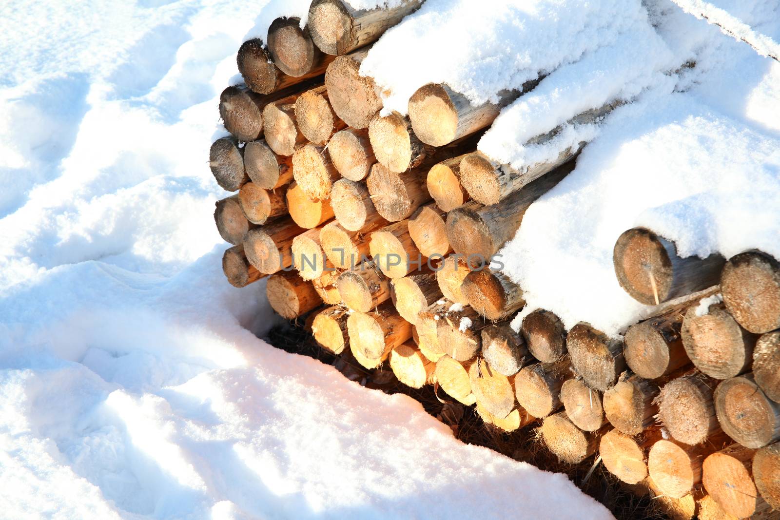 Wood bundle of rails covered in snow