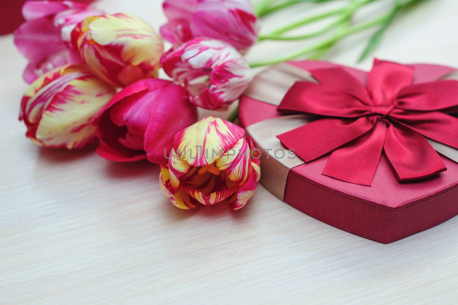 bouquet of tulips and gift box with red bow.
