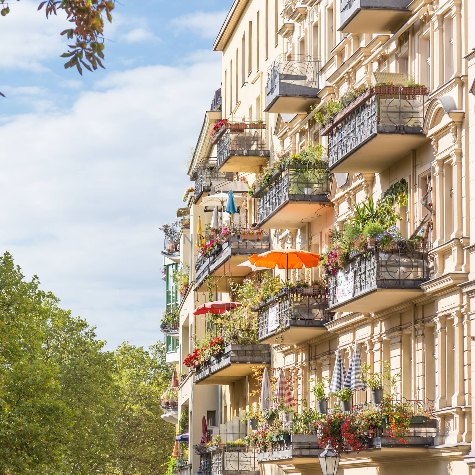 Traditional European residential house with balconys with colorful flowers and flowerpots. Kreuzberg neighborhood, Berlin, Germany,