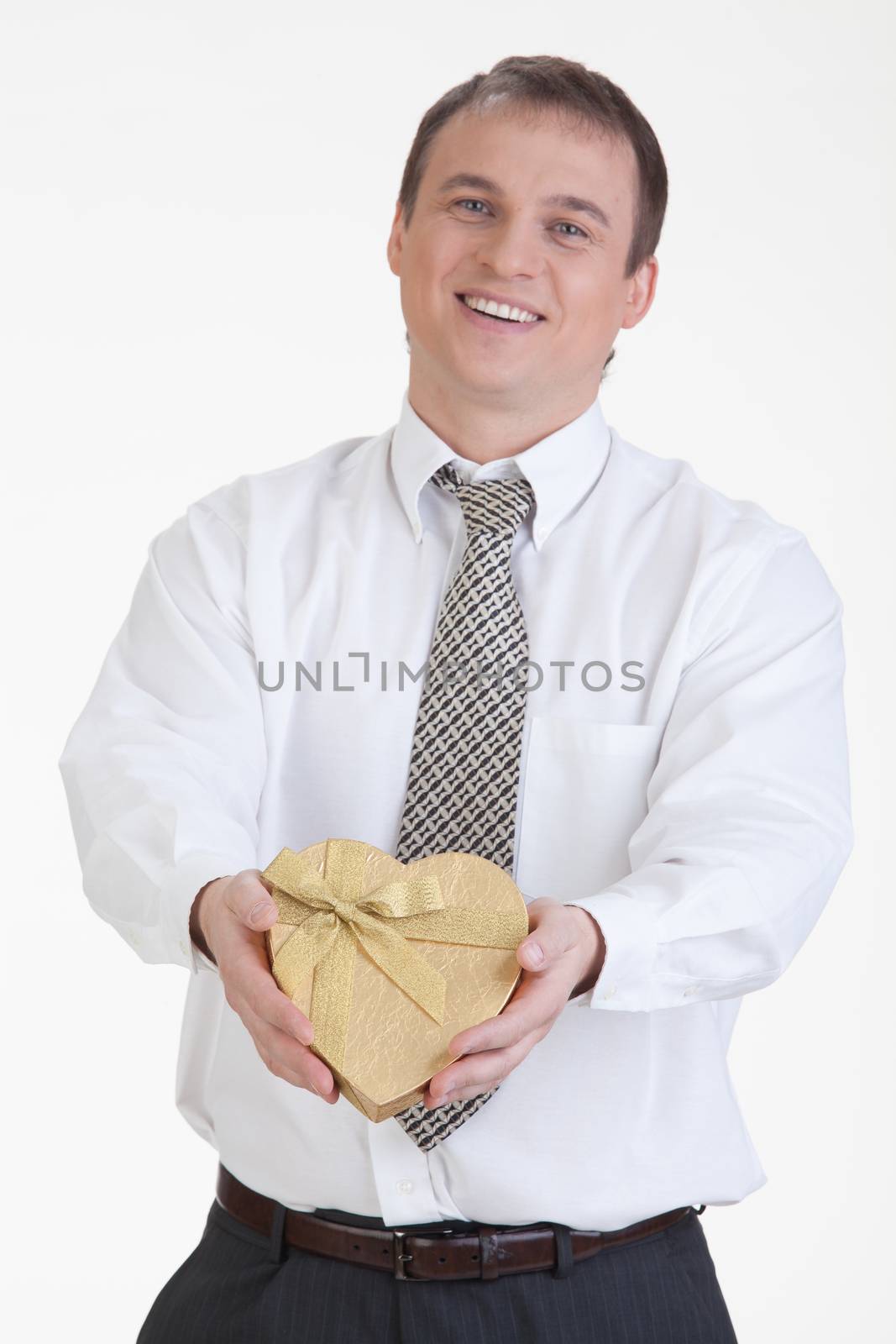 Young man with a heart shaped box in his hand on a white background