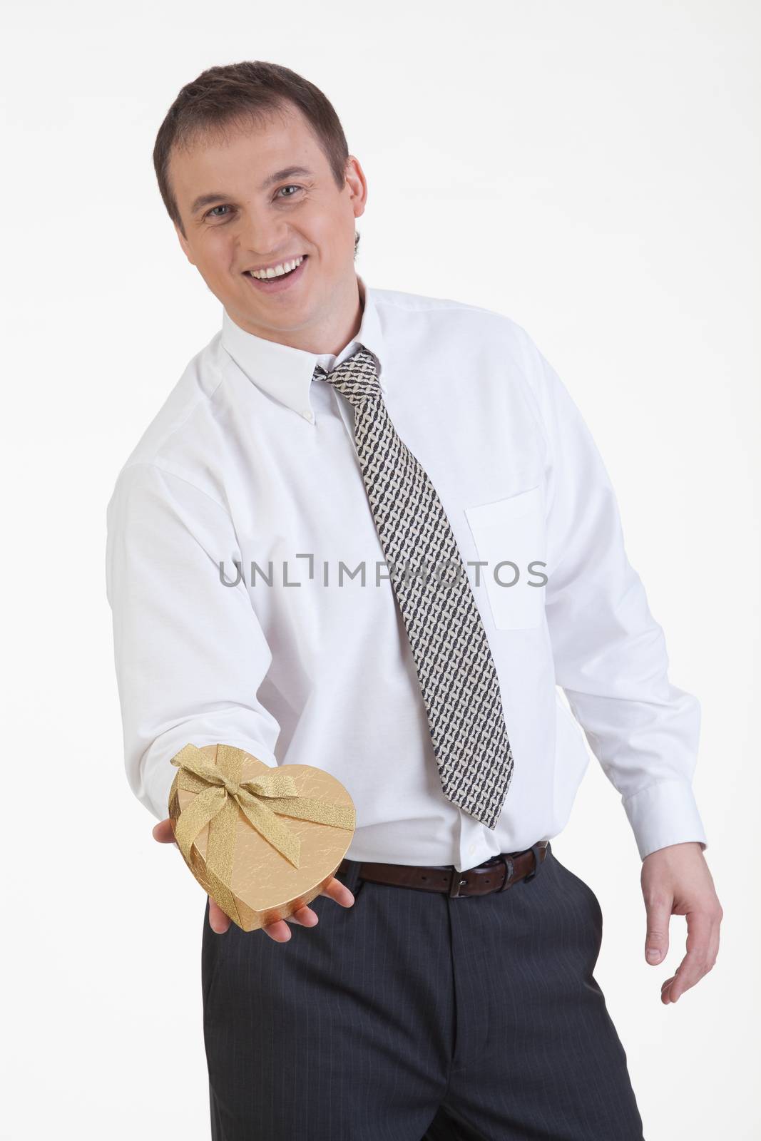 Young man with a heart shaped box in his hand on a white background