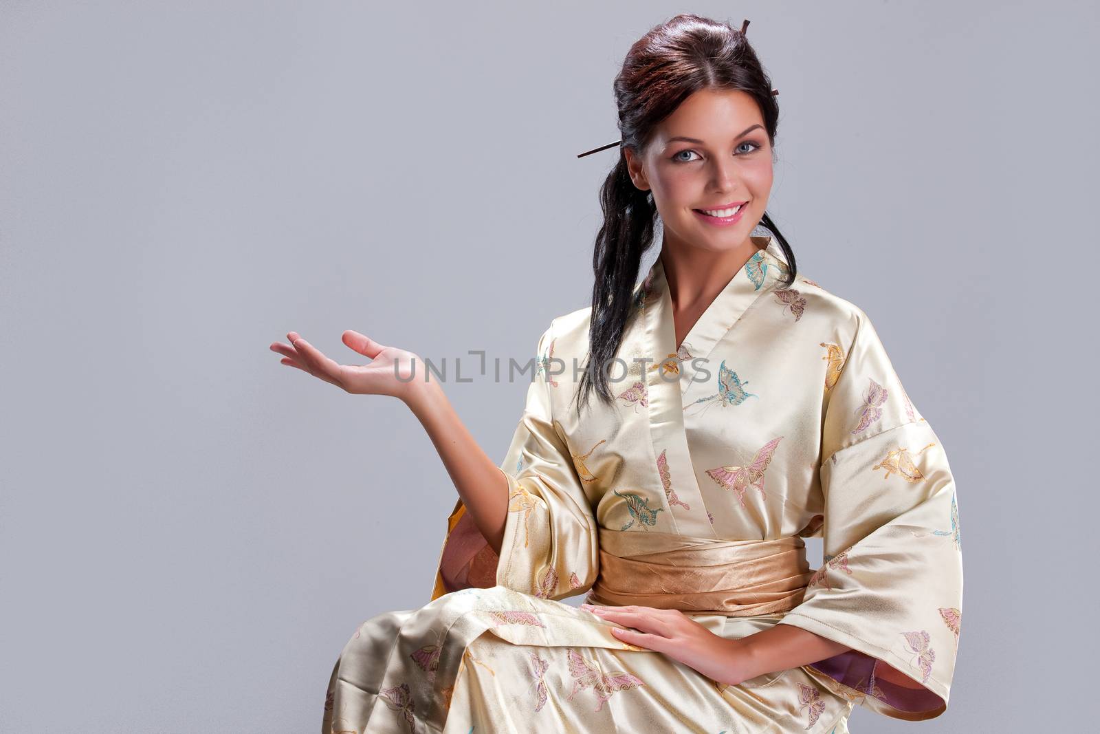 Young beautiful woman in japanese national clothing on an isolated studio background