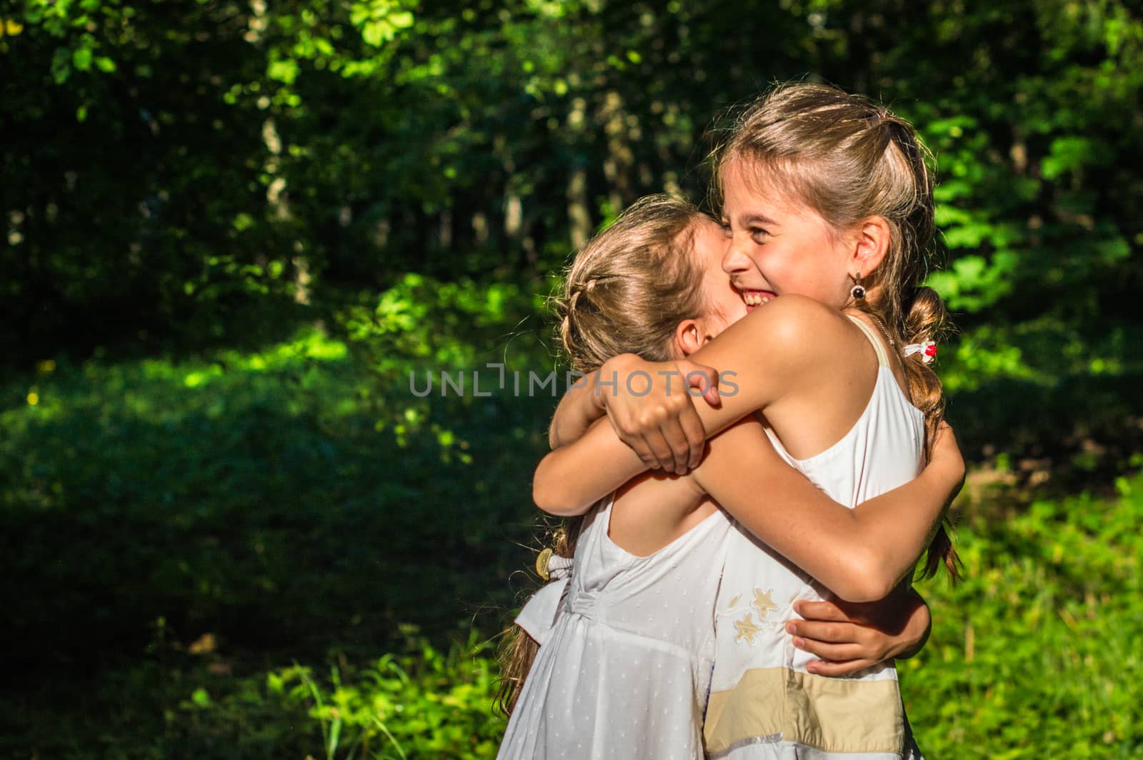 two daughters hugging in the park by okskukuruza