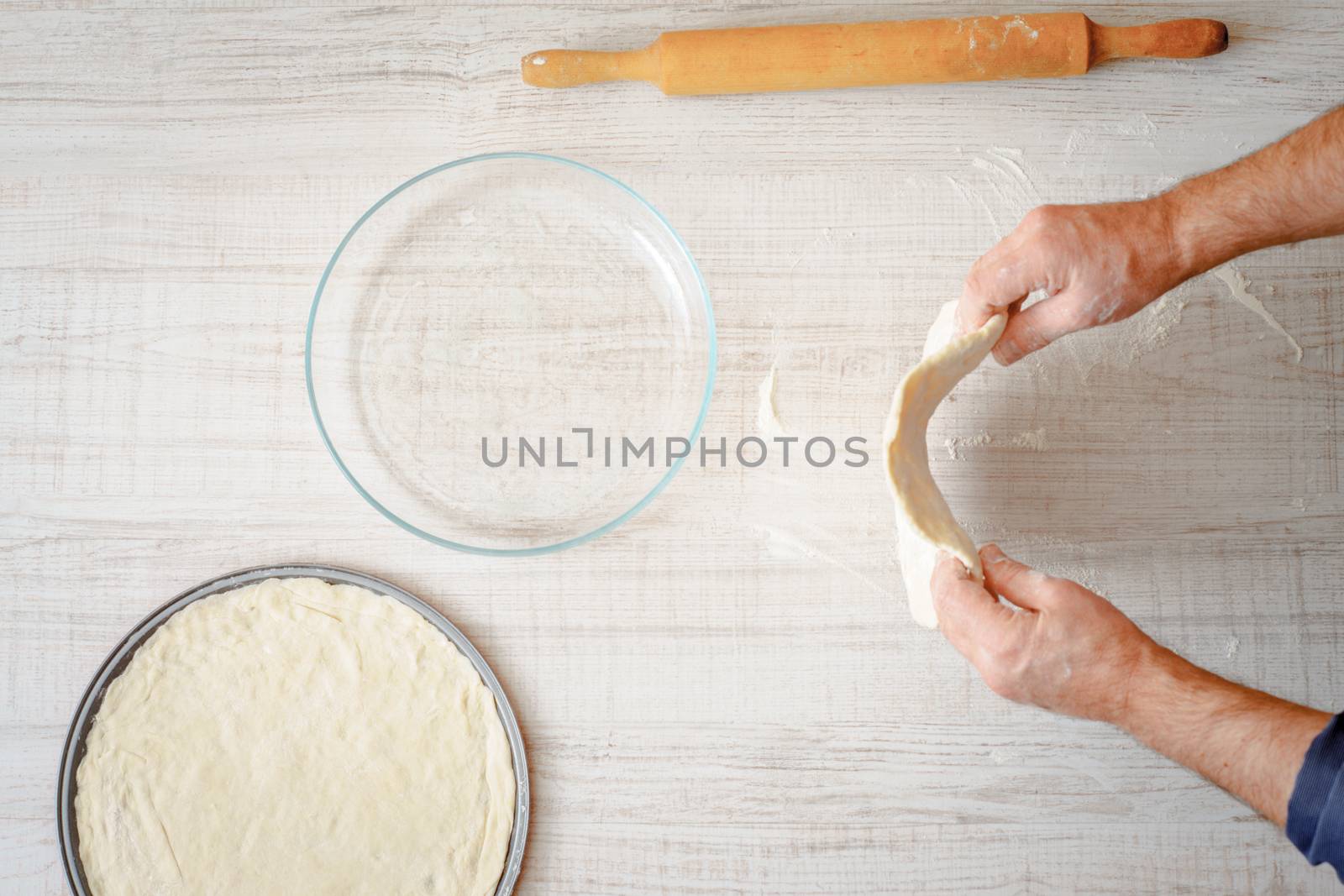 Cooking pizza dough on the table by Deniskarpenkov