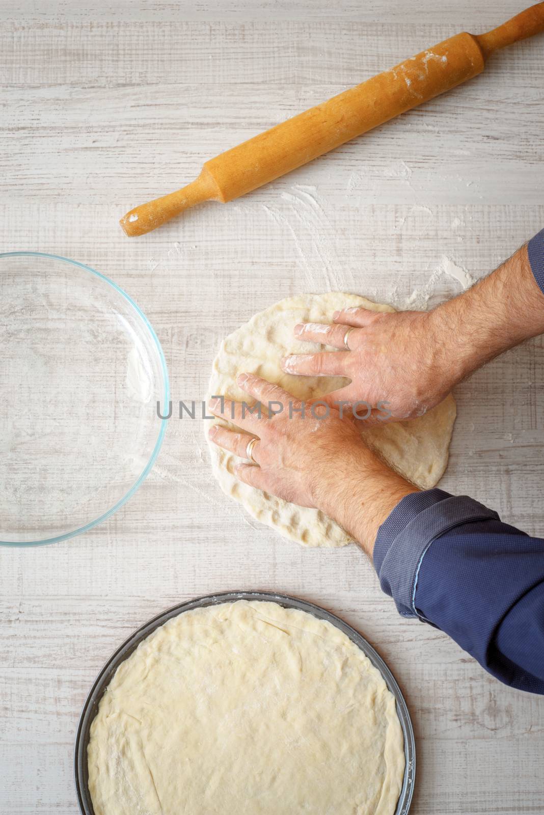 Cooking pizza dough on the wooden table by Deniskarpenkov