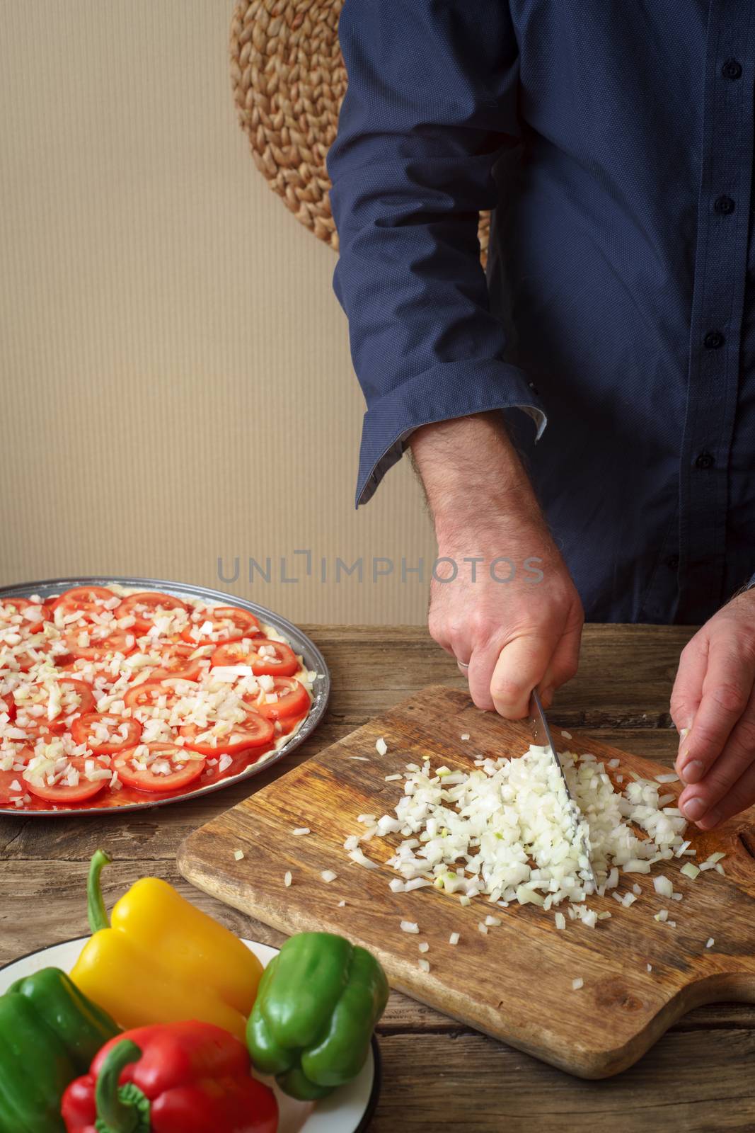 Man knife sliced onion pizza on a cutting board vertical
