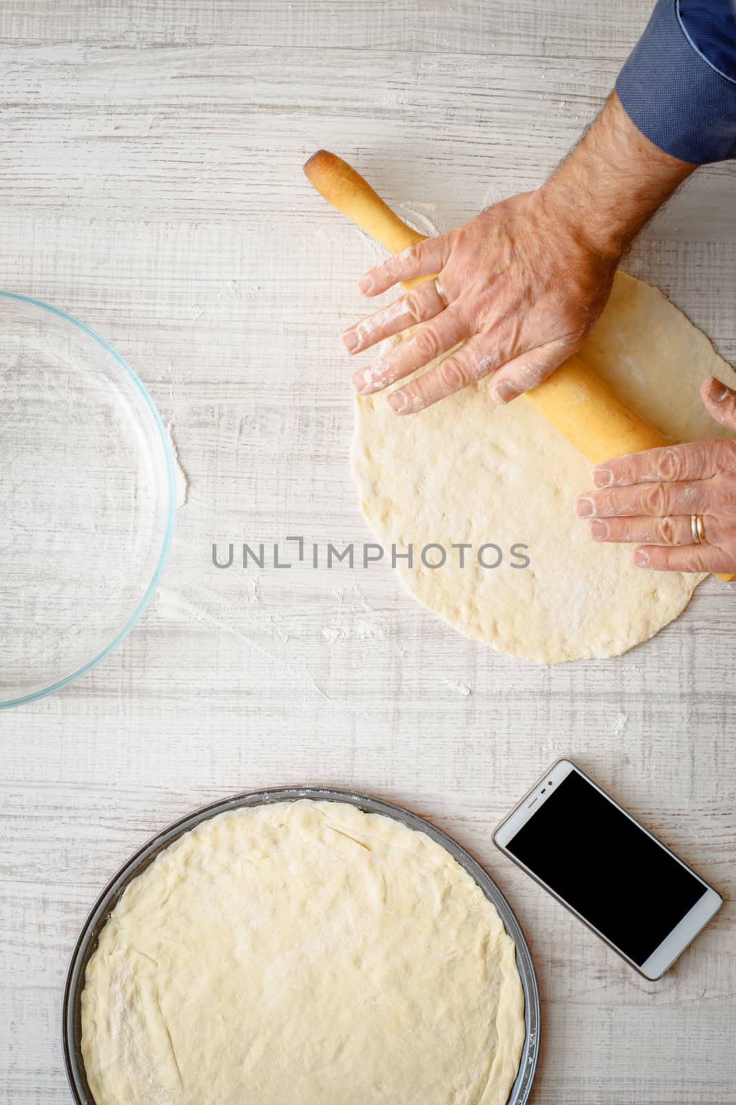 Man cooking dough for two pizzas on the kitchen vertical