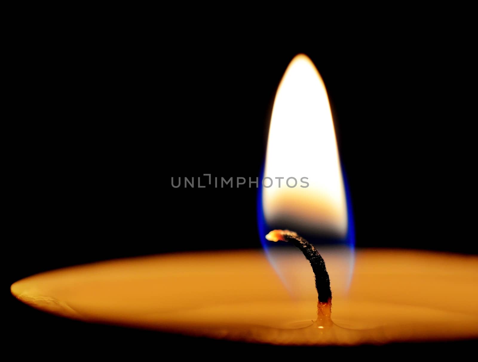 Burning wax candle at night closeup.