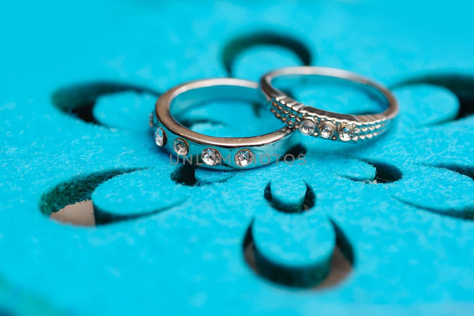 two wedding rings white gold on a turquoise background.