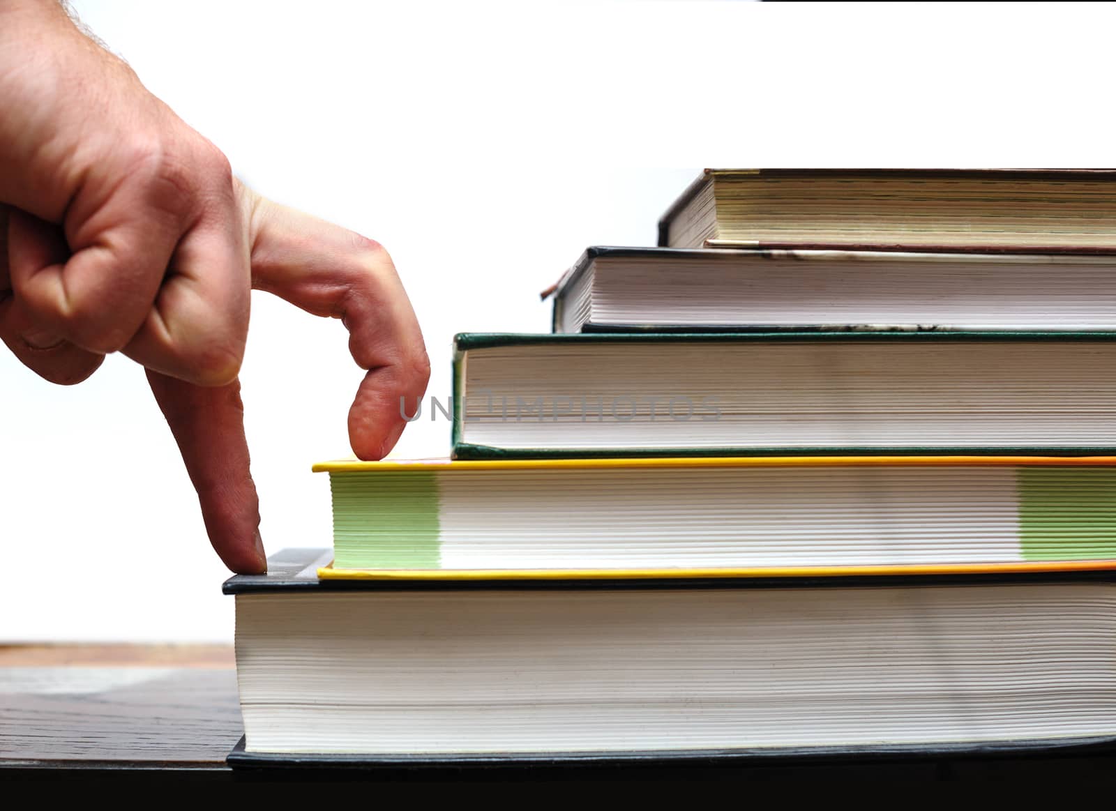 fingers of the hand up the stairs of books. education concept.