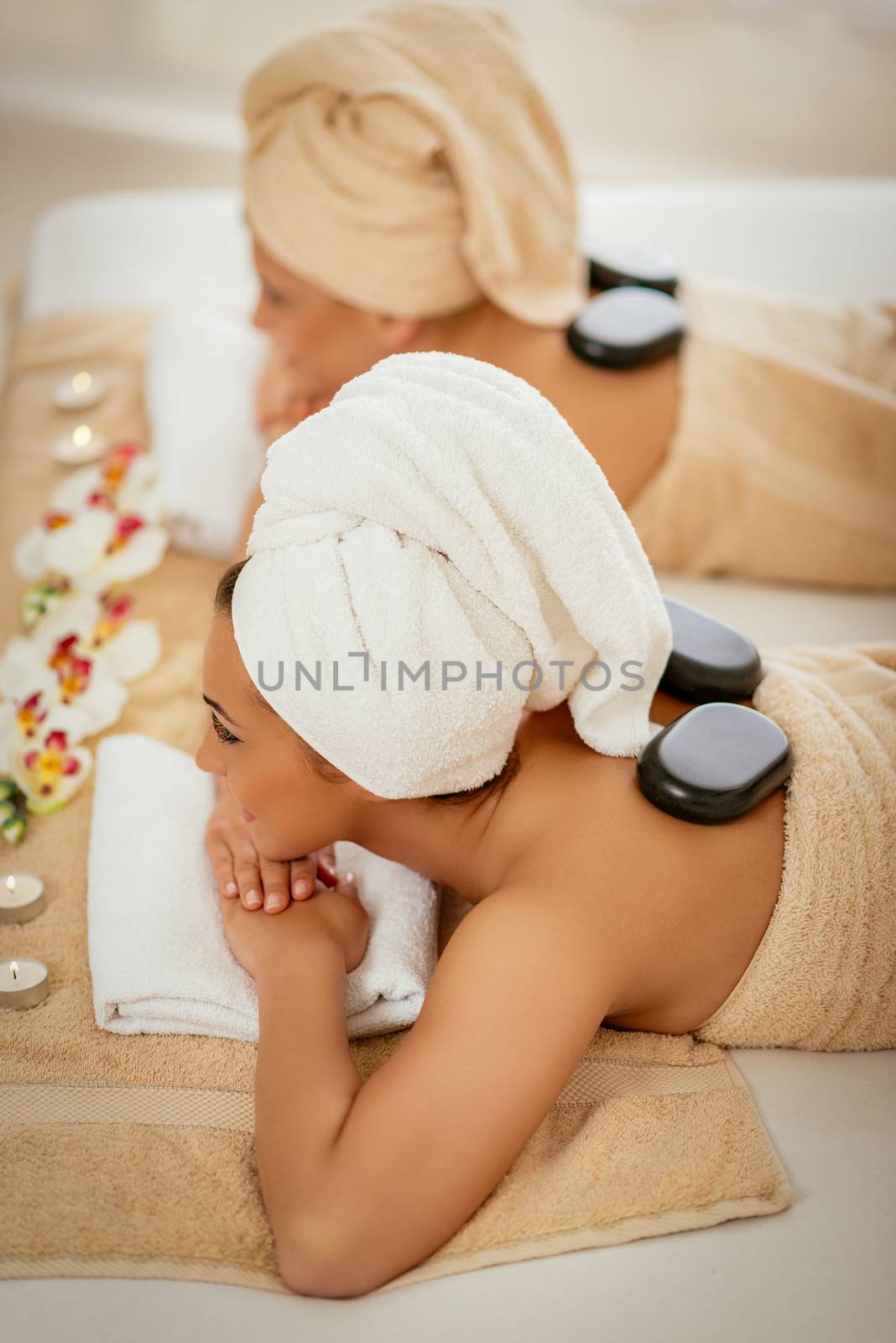 Two cute young women enjoying during a skin care treatment at a spa.