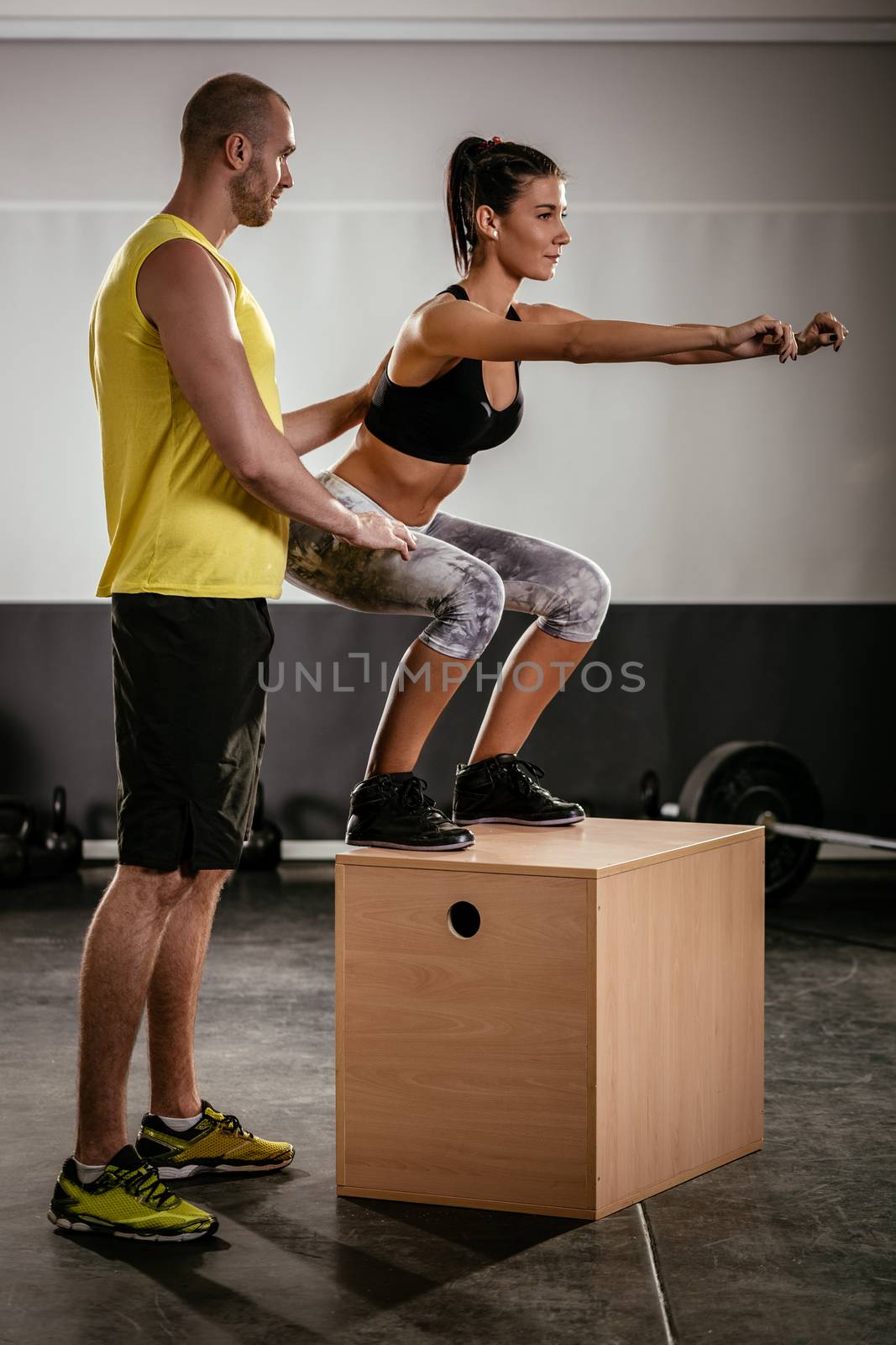Woman exercising at the gym with a personal trainer.