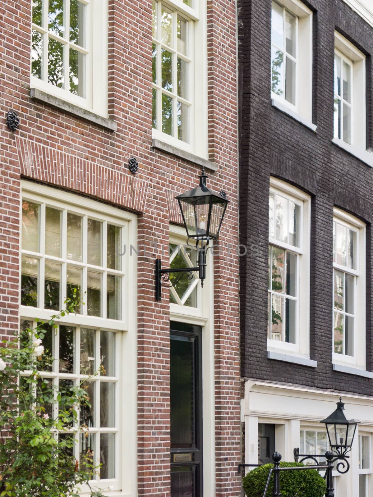 House in in a street by a canal in Amsterdam by chrisukphoto